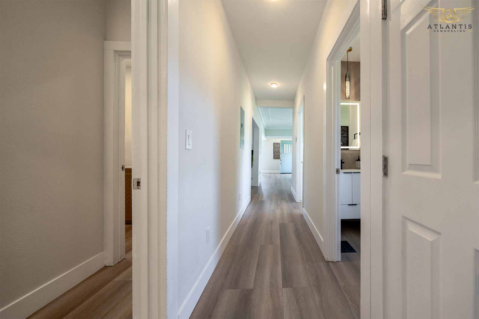 Modern hallway with luxury vinyl plank flooring connecting bedrooms and bathrooms